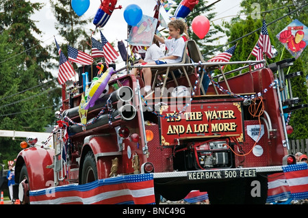 Back view of a festive fire truck as it moves along the parade route in Tumwater, Washington on the 4th of July. Stock Photo