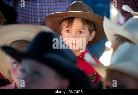 A six-year-old boy stands among other children at the rodeo. Stock Photo