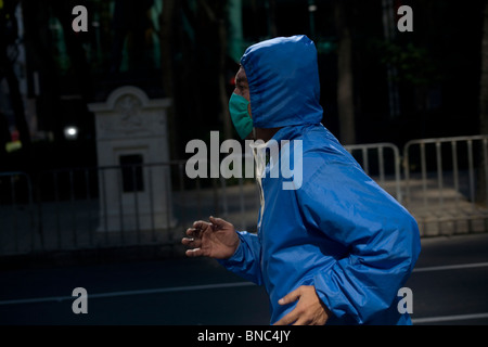 An man wears a surgical mask as a precaution against pollution as he jogs in Mexico City, December 13, 2009. Stock Photo