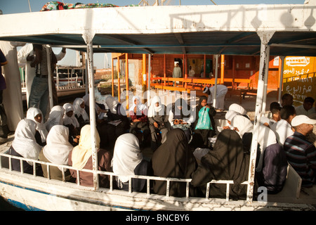 Egypt lifestyle; Local nubian egyptian women on board a ferry to take them across the river Nile to work in Aswan, Upper Egypt Africa Stock Photo