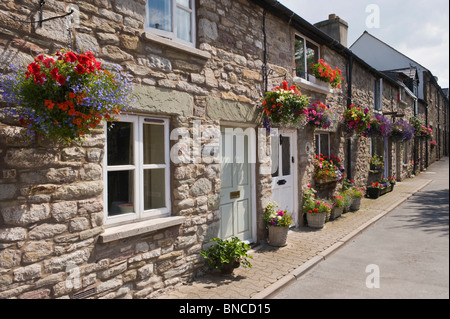 Picturesque row of terraced cottages with hanging baskets outside in Hay-on-Wye Powys Wales UK Stock Photo