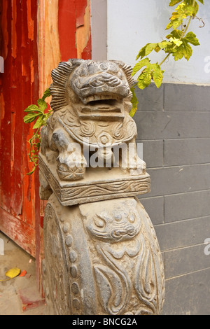 Rough stone lion figure on the corner of a doorway in hutongs, Beijing, China Stock Photo
