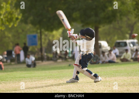 Boy playing cricket in a playground, New Delhi, India Stock Photo
