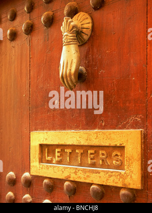 Brass door knocker on an old red door in Marrakesh, Morocco Stock Photo