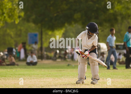 Boy playing cricket in a playground, New Delhi, India Stock Photo