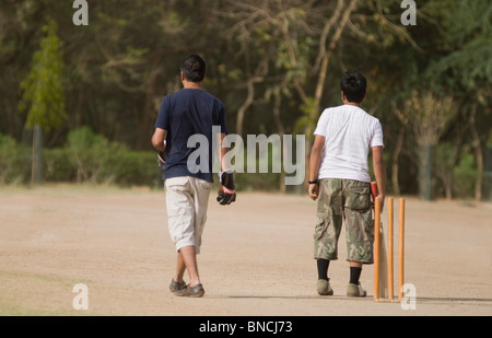 Boys playing cricket in a playground, New Delhi, India Stock Photo