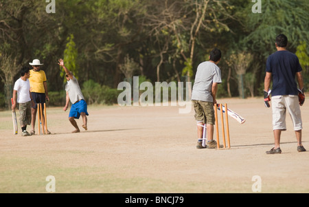 Boys playing cricket in a playground, New Delhi, India Stock Photo