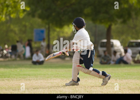 Boy playing cricket in a playground, New Delhi, India Stock Photo