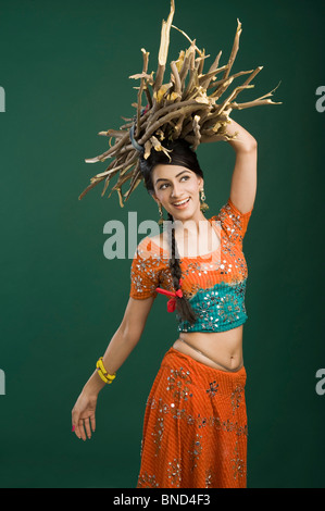 Woman carrying a bundle of firewood on her head Stock Photo