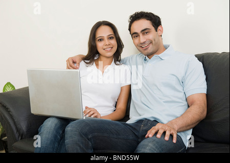 Couple using a laptop and smiling Stock Photo