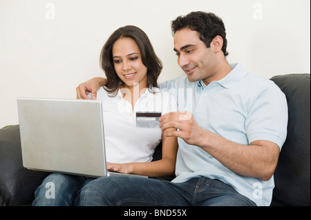 Couple doing online shopping with a laptop Stock Photo