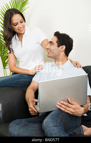Couple using a laptop and smiling Stock Photo