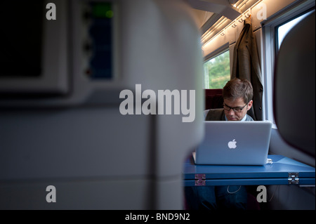 Businessman working on laptop in first class carriage on German ICE high speed express train Stock Photo