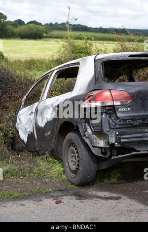 burned out stolen volkswagen golf car crashed into a ditch in northern ireland in the uk Stock Photo