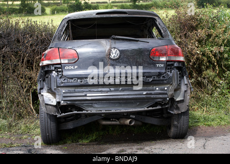 burned out stolen volkswagen golf car crashed into a ditch in northern ireland in the uk Stock Photo