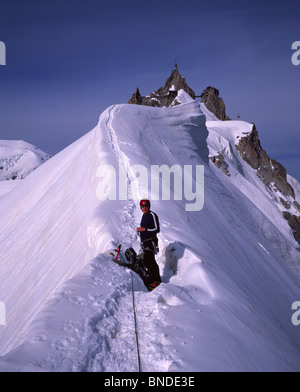 Climber on snow ridge in summer leading from Col du Plan to the Aiguille du Midi in the Mont Blanc Massif above Chamonix, Haute Savoie, France Stock Photo