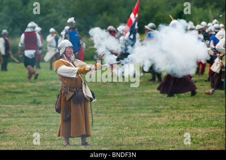 Medieval female gunner  firing a handgonne on the battlefield at the Tewkesbury medieval festival 2010. Tewkesbury, Gloucestershire, England Stock Photo