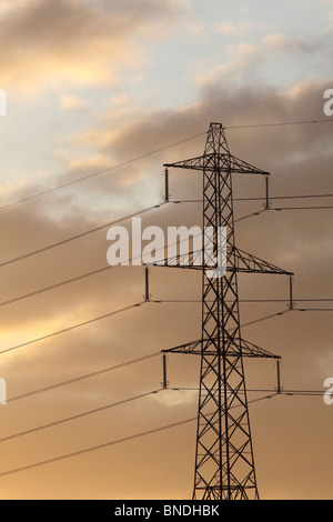 Sunset behind power pylon Stock Photo