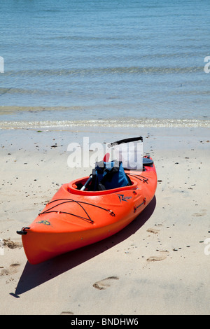 Lone canoe in  St Ives, Cornwall, England sat at the waterside on beach waiting to be pushed out Stock Photo
