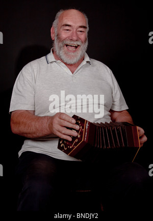 Happy bearded man playing concertina Stock Photo