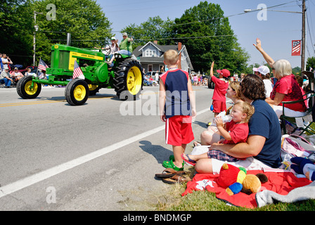 Family Watching John Deere Tractor in the Oldest Continuous Independence Day Parade in America in Pekin, Indiana Stock Photo