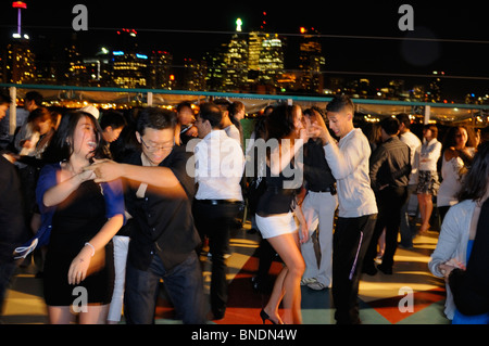 University students practicing on a latin dance club boat cruise with Toronto skyline at night Stock Photo