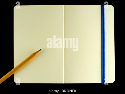 Classic opened moleskine note book with pencil isolated on black background Stock Photo