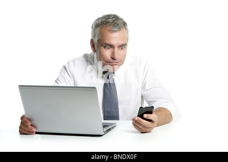 surprised senior businessman expression gesture mobile phone laptop gray hair Stock Photo