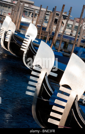 Evening sun shining on prows of gondolas moored n Grand Canal in Venice Italy
