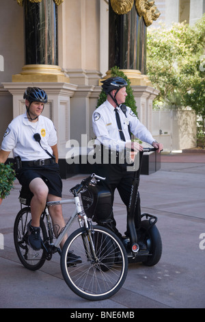 Two Andrews security guards on duty outside Caesar's Palace shopping mall casino hotel in Las Vegas - on bicycle and Segway Stock Photo