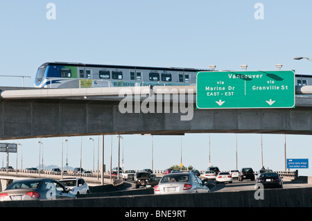 A Canada Line public transit SkyTrain passes over cars on the Arthur Laing Bridge on its way to Vancouver International Airport. Stock Photo