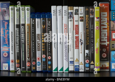 row of dvd vhs blu-ray video cases and wii and xbox360 video games on a shelf in the uk Stock Photo