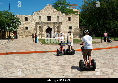 Tourists and sightseers on segways posing for photograph at historic Alamo mission, symbol of Texas Independence in Texas, USA Stock Photo