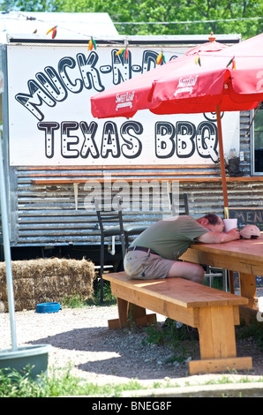 Man sleeping in front of trailer cafe Texas, USA Stock Photo