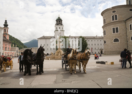 Salzburg Austria EU Horse drawn carriages in Residenzplatz waiting to take tourists on a tour of this lovely city Stock Photo
