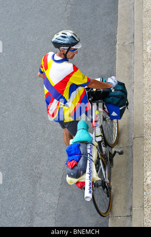 Touring cyclist waiting at kerb - France. Stock Photo