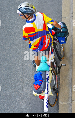 Touring cyclist waiting at kerb - France. Stock Photo