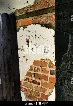 brick wall with plaster and graffiti "get nice" fence Stock Photo