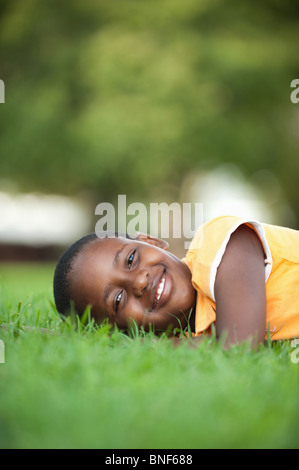 Portrait of girl (8-9) lying on grass in garden, Johannesburg, Gauteng Province, South Africa Stock Photo