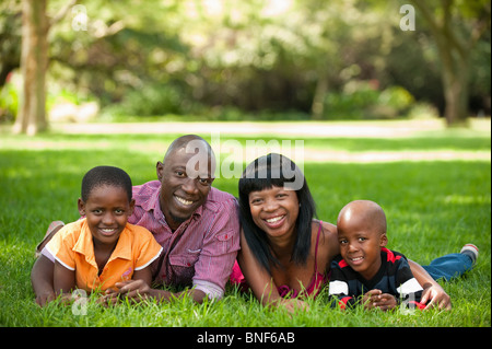 Portrait of family with children (4-8) lying on grass, Johannesburg, Gauteng Province, South Africa