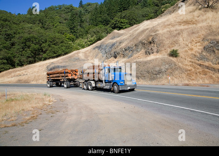 A logging truck carrying redwood and cedar longs on a California coastal highway Stock Photo