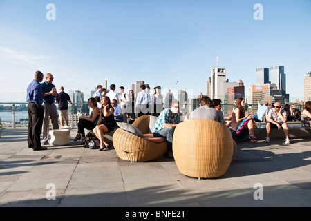 diverse crowd smiling young people dressed for casual Friday enjoy panoramic view from Ink 48 hotel Print rooftop bar NYC Stock Photo