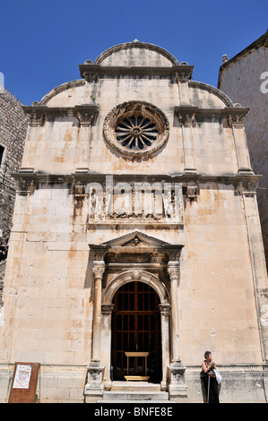 A tourist stands before the impressive facade of the Church of St Saviour which escaped damage from a strong earthquake in 1667 Stock Photo