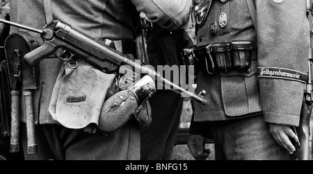 WW2 German army soldier with officer carrying MP40 9 mm submachine gun. Historical re enactment. Monochrome Stock Photo