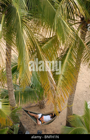 Man lying in a hammock, listening to music,Playa Azul, Luquillo, Puerto Rico Stock Photo