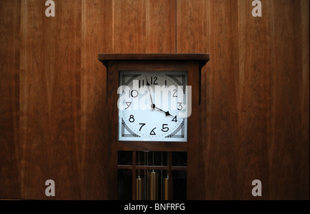 Modern clean grandfather clock against wooden wall Stock Photo