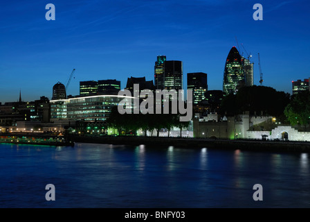 City of London UK skyline, illuminated at dusk, viewed from the South Bank, including the Gherkin and the NatWest Tower Stock Photo