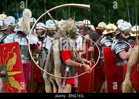 Roman soldier (Cornicen) with cornu in front of the garrison at a historical reenactment living history display Stock Photo