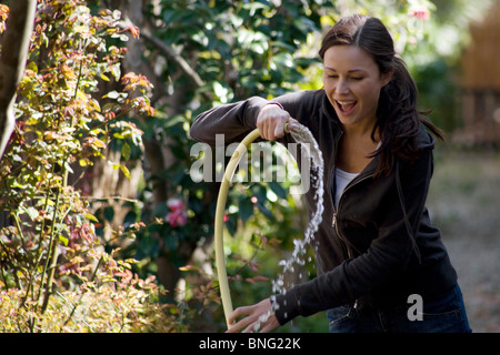 young woman with hosepipe Stock Photo