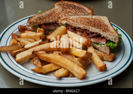 A bacon, lettuce, and tomato sandwich is served with French fries (chips) in a restaurant in Southern Ontario. Stock Photo